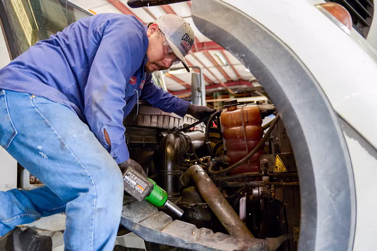Mechanic performing diesel repair services on truck